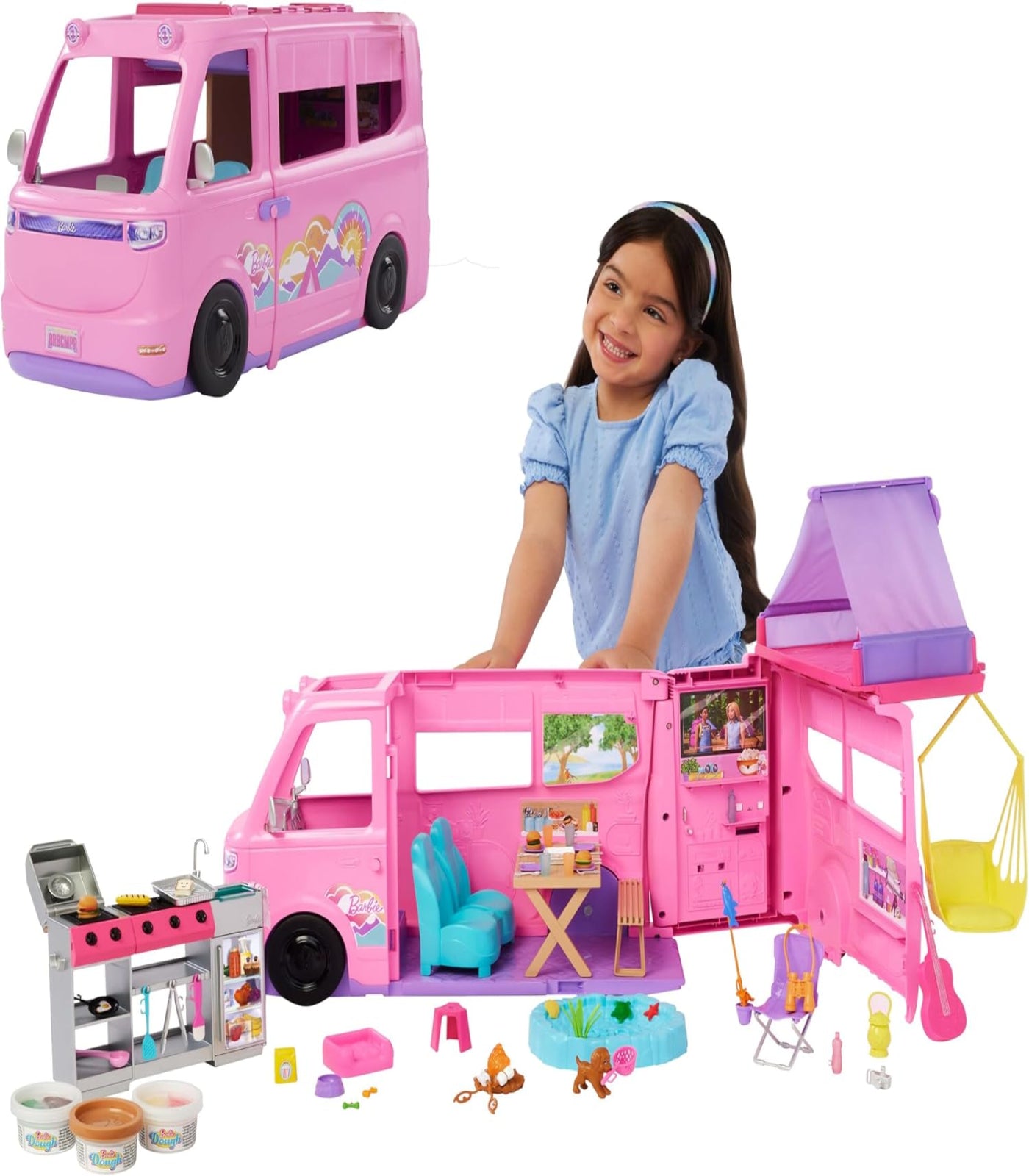 Pink toy camper with detailed interior and accessories, including a girl standing next to it.