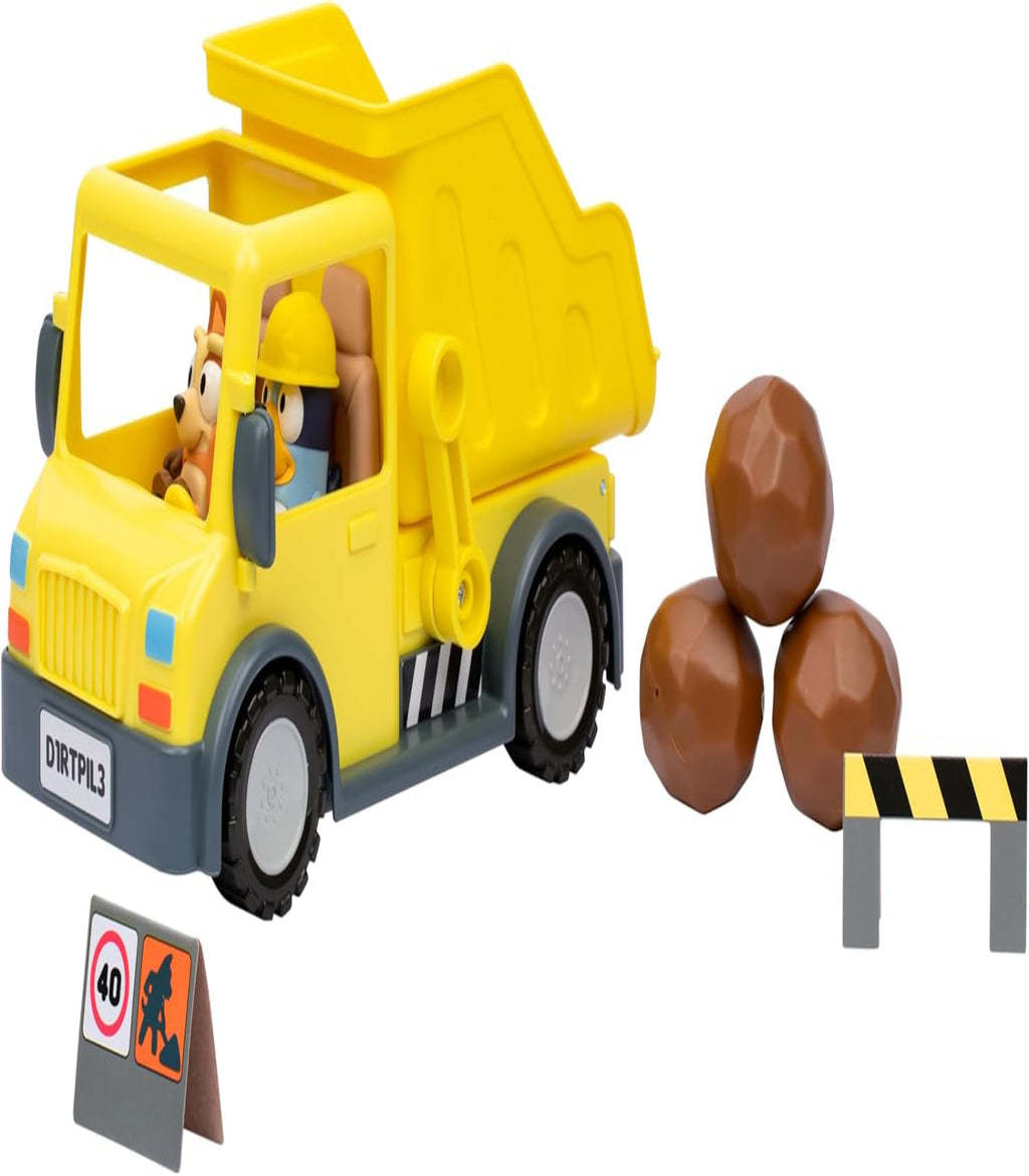 Toy dump truck with a driver figure, rocks, and traffic signs on a white background