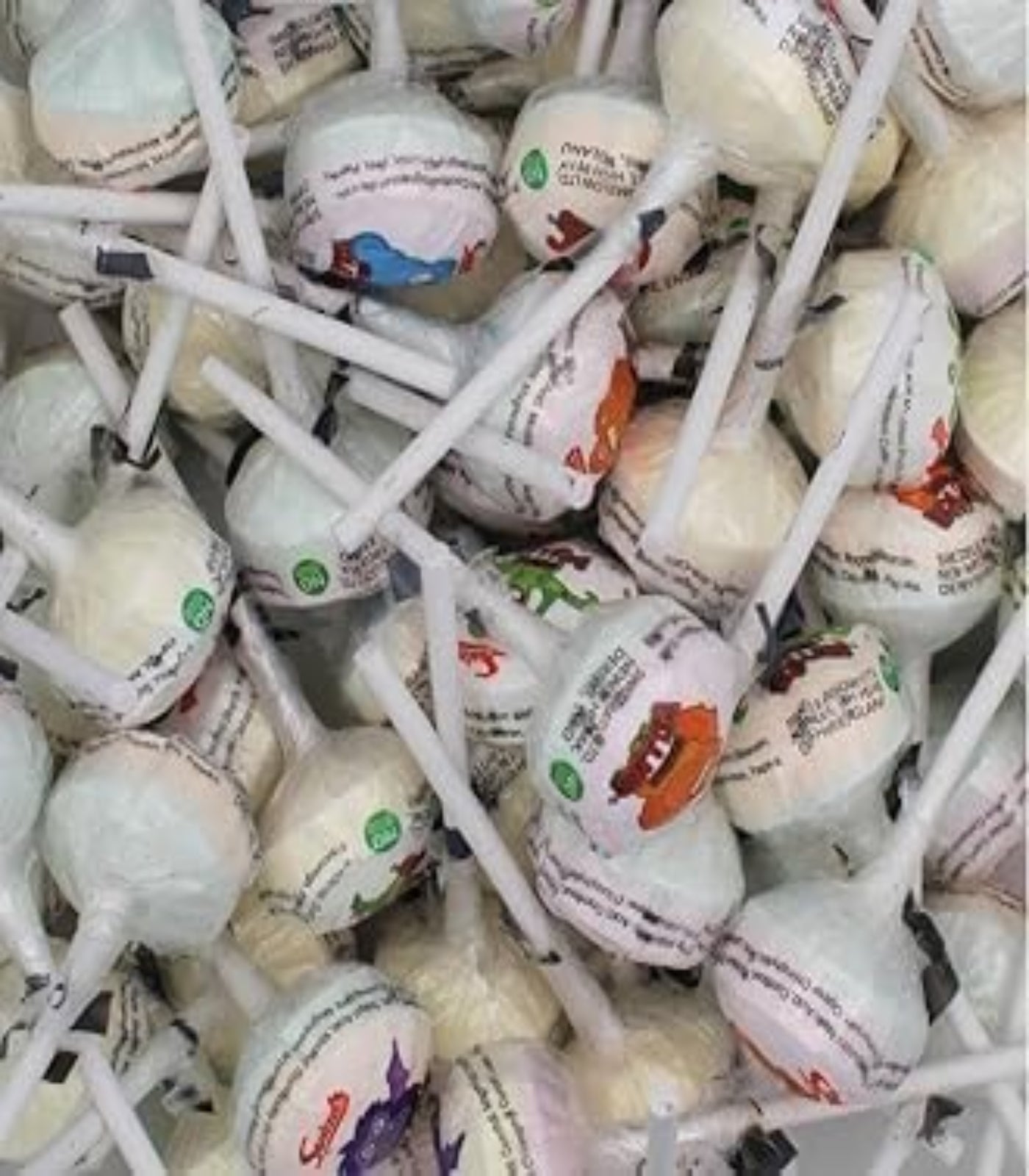 Assorted lollipops on sticks with colorful labels in a pile.