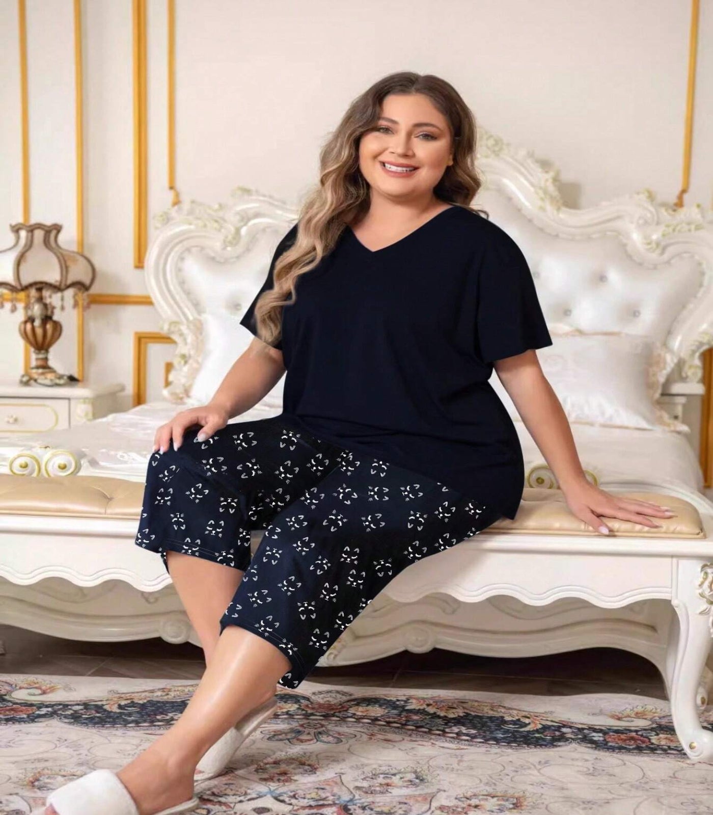 Woman wearing a navy blue outfit with floral patterns sitting on a decorative chair.