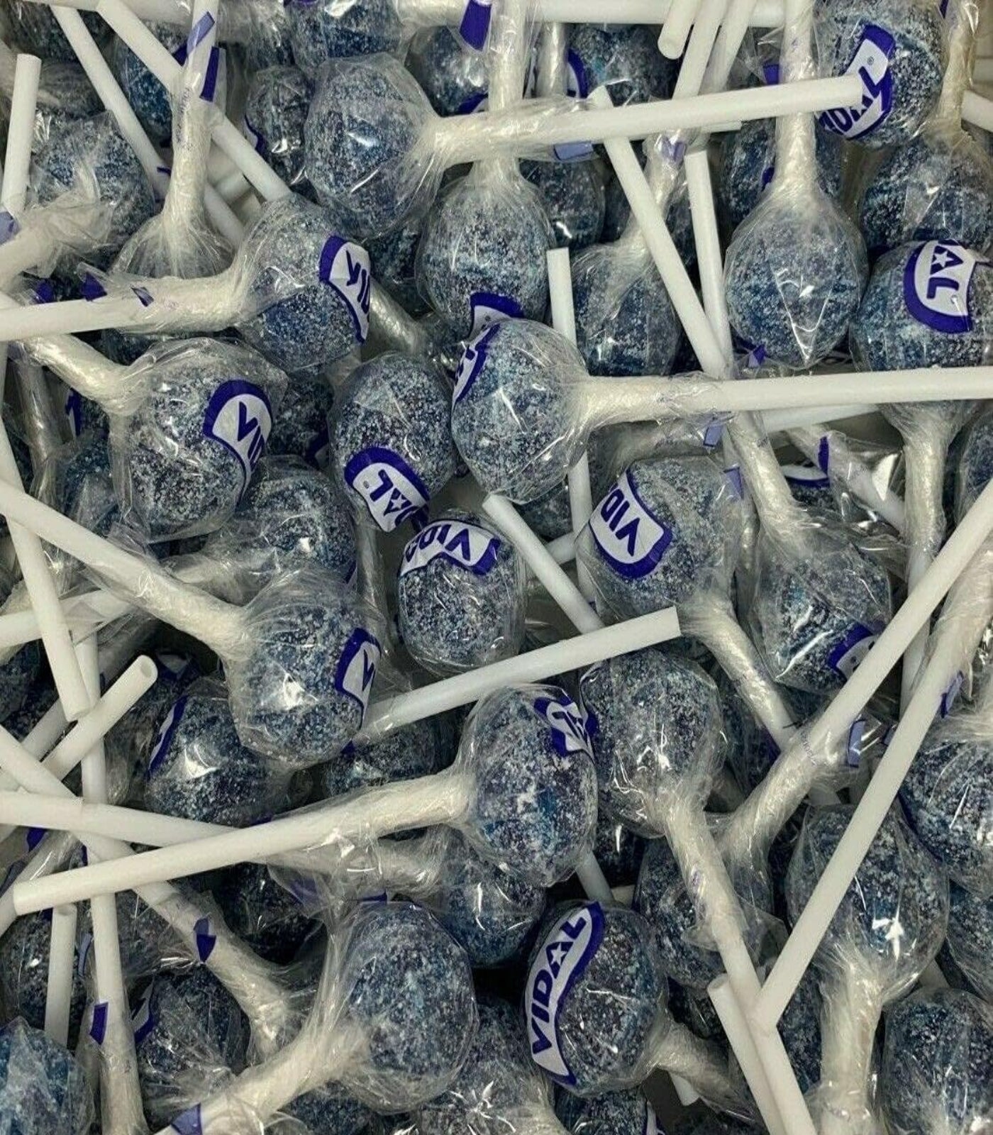 Large quantity of blue lollipops with visible 'VIDAL' branding on sticks.