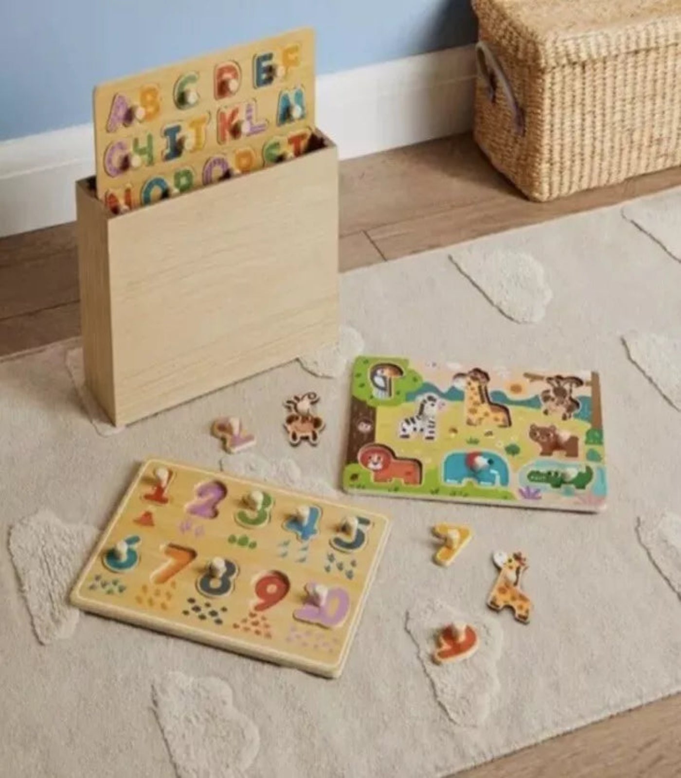 Wooden educational toys for children on a rug with a basket in the background.